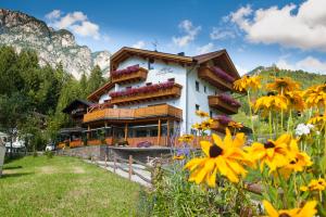 a building with flowers in front of it at Residence Rosengarten - Alpenglühen zum Anfassen, inklusive Guestpass in Tires
