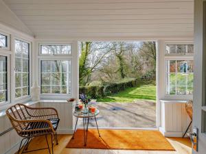 a room with a large window and a table and chairs at 6 Bed in Abergele oc-91054 in Llanddulas