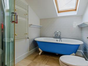 a bathroom with a blue tub and a toilet at 6 Bed in Abergele oc-91054 in Llanddulas +34 photos