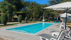 a swimming pool with chairs and an umbrella at Matcha Lanta Resort in Ko Lanta