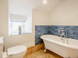 a bathroom with a white tub and a toilet at 6 Bed in Harlech oc-91546 in Harlech +41 photos