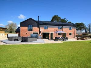 a brick house with a lawn in front of it at 14 Bed in Welshpool oc-90568 in Berriew