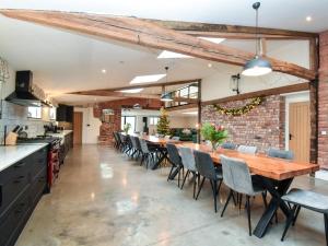 a large kitchen with a long wooden table and chairs at 14 Bed in Welshpool oc-90568 in Berriew