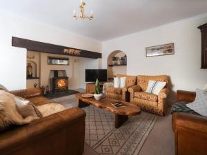 a living room with leather furniture and a fireplace at 5 Bed in Aberystwyth oc-58889 in Llanrhystyd