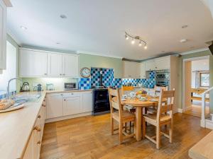 a kitchen with a table and chairs in a kitchen at 5 Bed in Aberystwyth oc-58889 in Llanrhystyd