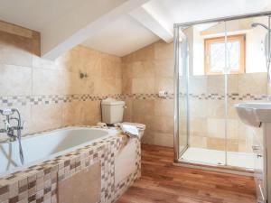 a bathroom with a tub and a shower and a sink at 5 Bed in Aberystwyth oc-58889 in Llanrhystyd +26 photos