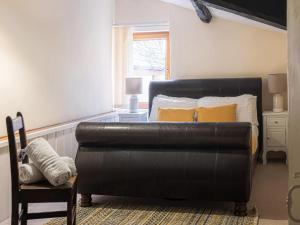 a black leather couch in a bedroom with a bed at 5 Bed in Aberystwyth oc-58889 in Llanrhystyd
