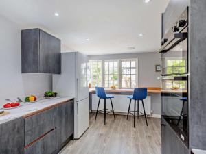 a kitchen with two blue bar stools in it at 4 Bed in Beaumaris oc-94501 in Llanddona