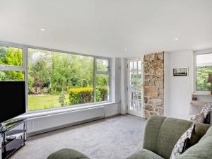 a living room with a couch and a large window at 4 Bed in Beaumaris oc-94501 in Llanddona