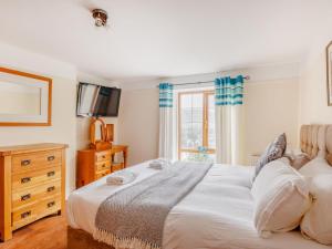 a bedroom with a white bed and a window at 3 Bed in Corwen oc-90459 in Corwen