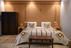 a bedroom with a large bed and a bench at Bihi Lodge in Tahannout +48 photos
