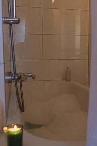 a bath tub with a candle in a bathroom at JETHON Appartement in der Gasse 2 in Grimschleben +11 photos