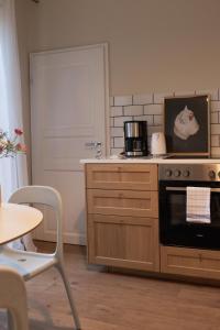 a kitchen with a stove and a table and a door at JETHON Appartement in der Gasse 2 in Grimschleben