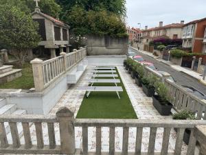a white picnic table sitting on a sidewalk next to a street at Villa Hermida in Sanxenxo
