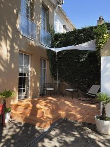 a patio with chairs and a white canopy in front of a building at JETHON Appartement in der Gasse 2 in Grimschleben