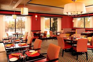 a dining room with tables and chairs and windows at Four Points by Sheraton Wakefield Boston Hotel & Conference Center in Wakefield