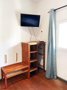 a room with a tv on a wall with a bench at Jiro Hôtel in Antananarivo