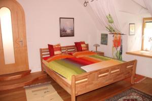 a bedroom with a large wooden bed with colorful sheets at Ferienwohnung Vorstadt in Gmünd in Kärnten