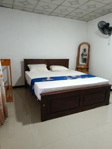 a bedroom with a large bed with a wooden frame at Green Serenity Villa in Ahangama