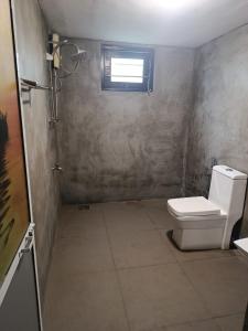 a bathroom with a toilet and a window at Green Serenity Villa in Ahangama