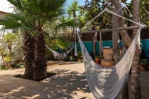 a hammock between two palm trees on a patio at Ticket2Surf in Palheiros da Tocha