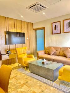 a living room with a couch and chairs and a table at Residence 541 Apartments and Suites in Abuja