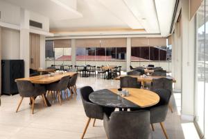 a restaurant with wooden tables and chairs and a large window at Atik Hotel Nişantaşı in Istanbul