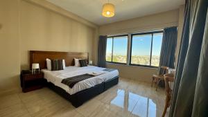a bedroom with a bed and a large window at Antika Amman Hotel in Amman
