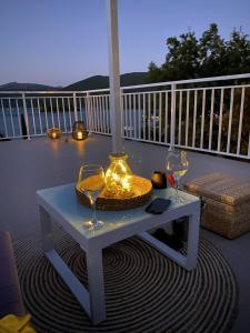 a table with two wine glasses on a balcony at Apartment MiriMore in Hodilje