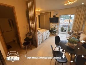 a room with a bed and a table and chairs at Studio Diamante no CENTRO com piscina, academia e opção de vaga privativa in Juiz de Fora +18 photos