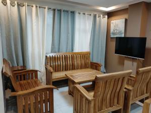 a living room with wooden furniture and a television at MEEK'S VILLAS TRANSIENT HOUSE in Baguio
