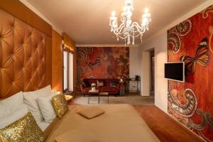 a bedroom with a large bed and a chandelier at Design Hotel Romantick in Třeboň