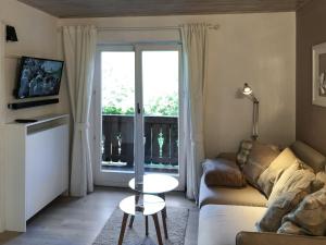 a living room with a couch and a table and a window at Bergromantik Ferienwohnung Charme mit einer Infrarotkabine und Bergblick in Marktschellenberg