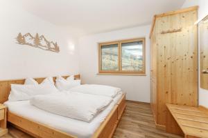 a bedroom with a bed and a window at Austrian Alpine Apartments in Ramsau am Dachstein