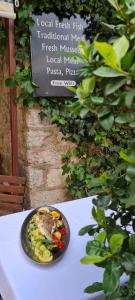 a plate of food on a table next to a sign at Step to Kotor Bay Old Town in Kotor