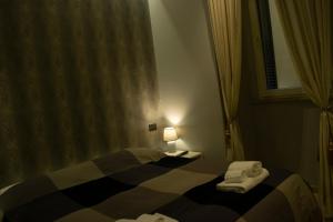 a bedroom with a bed with towels on it at ROMAnce Cosimato Trastevere B&B in Rome +45 photos