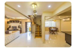 a living room with a staircase and a dining room at Avis Home in Calangute