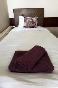 a purple towel laying on top of a bed at Kapija Grada in Ečka