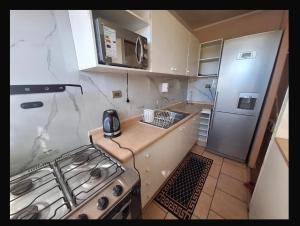 a small kitchen with a stove and a refrigerator at Departamento COPAYAPU in El Cerrillo +11 photos
