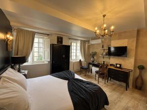 a bedroom with a bed and a desk and a television at hôtel particulier d'hôte le Philippe-le-Bel in Villeneuve-lès-Avignon