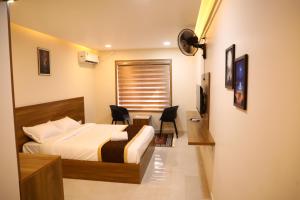 a bedroom with a bed and a desk and a television at Elara Residency Cheravathur in Cheruvattūr