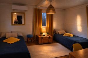 a room with two beds and a table and a mirror at Miodowy Zakątek Całoroczne Domki i Pokoje przy Suntago, Deepspot, Pyszne Śniadania, Grill in Mszczonów