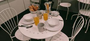 a table with plates and cups and glasses of orange juice at ROMAnce Cosimato Trastevere B&B in Rome