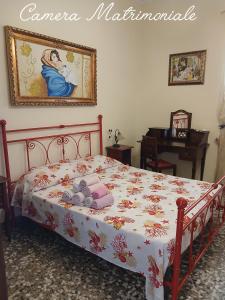 a bedroom with a bed and a painting on the wall at B&B IN VILLA in Gallipoli
