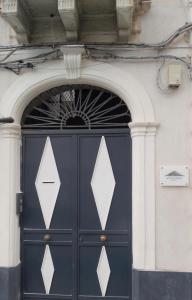 a blue door with white triangles on a building at Vulcano Rooms 3 in Catania