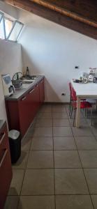 a kitchen with a sink and a table with red cabinets at Julias house in Biella +4 photos