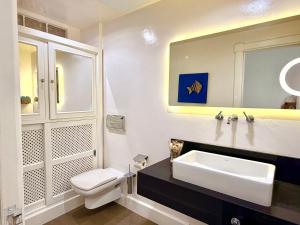 a white bathroom with a sink and a toilet at Famara ocean view house in Famara +47 photos
