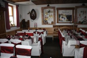 a dining room with white tables and red chairs at Pihringer's Moststub'n in Amstetten
