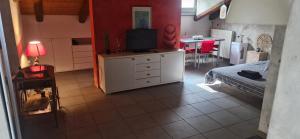 a living room with a bed and a television on a dresser at Julias house in Biella
