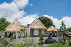 a group of huts with thatched roofs at Santhi Loka in Kubupenlokan